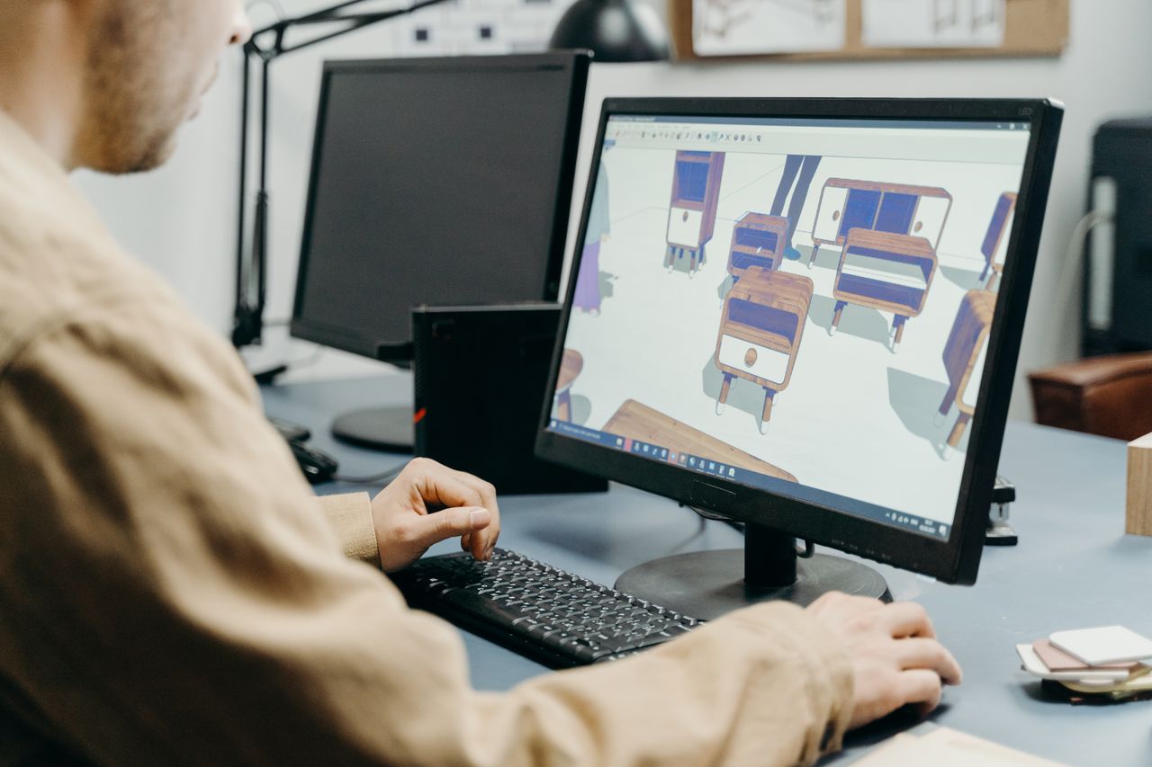 Mastering the First Impression: Your intriguing post title goes here A product designer using a computer for 3D furniture modeling in an office setting.